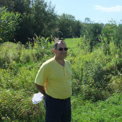 Landowner poses in front of natural area