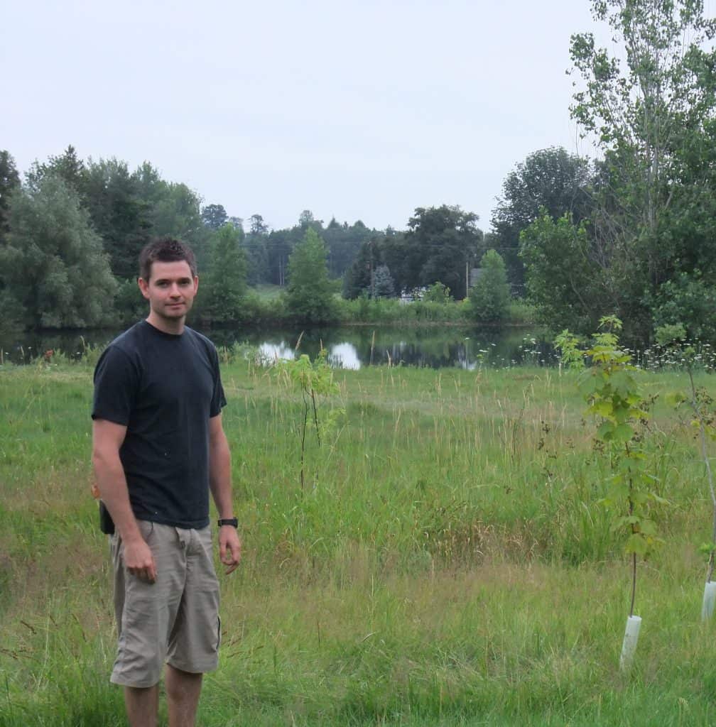 Participant standing in front of newly planted trees