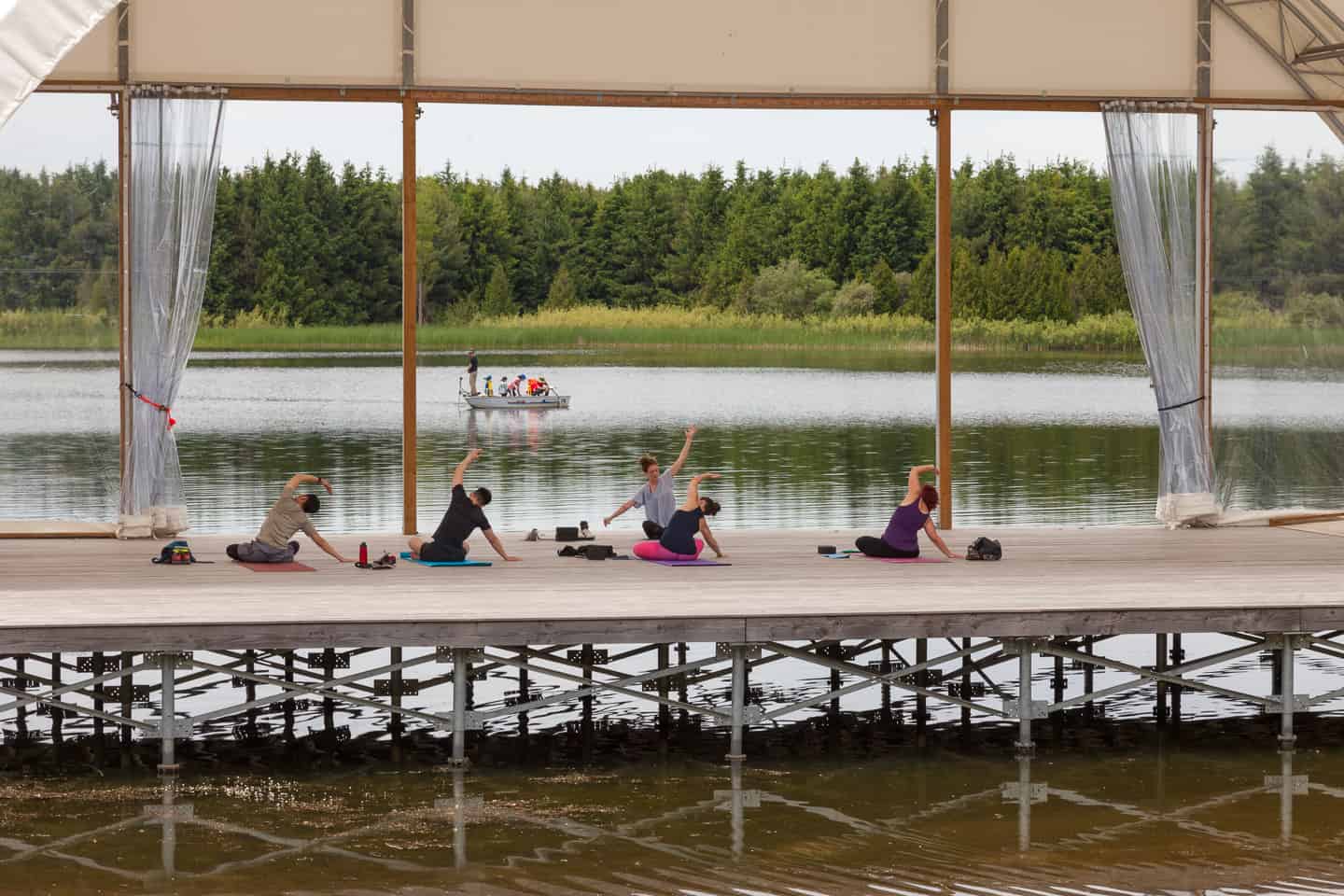 People practicing yoga along the lake